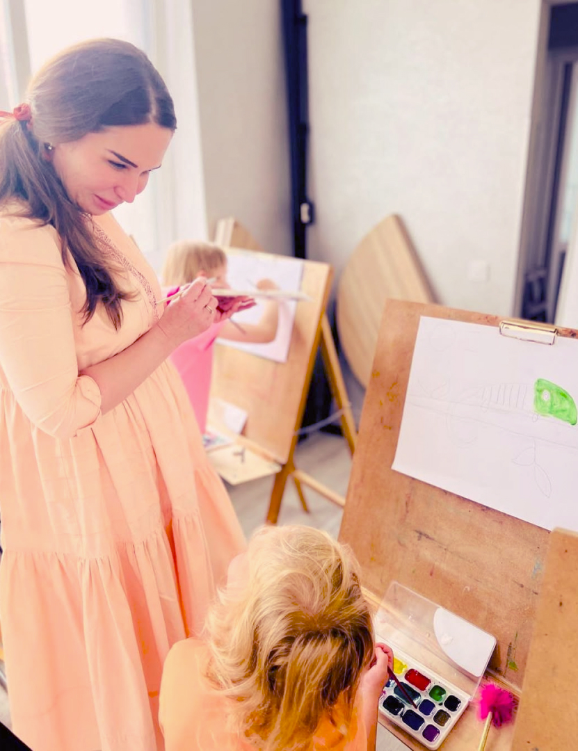 Учні молодшої школи на уроці малювання з вихователем у класі приватної школи