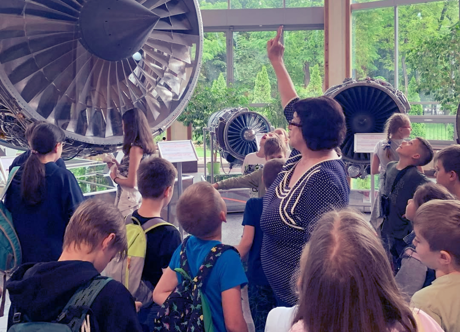 Екскурсія до музею де екскурсовод показує на частину турбіни