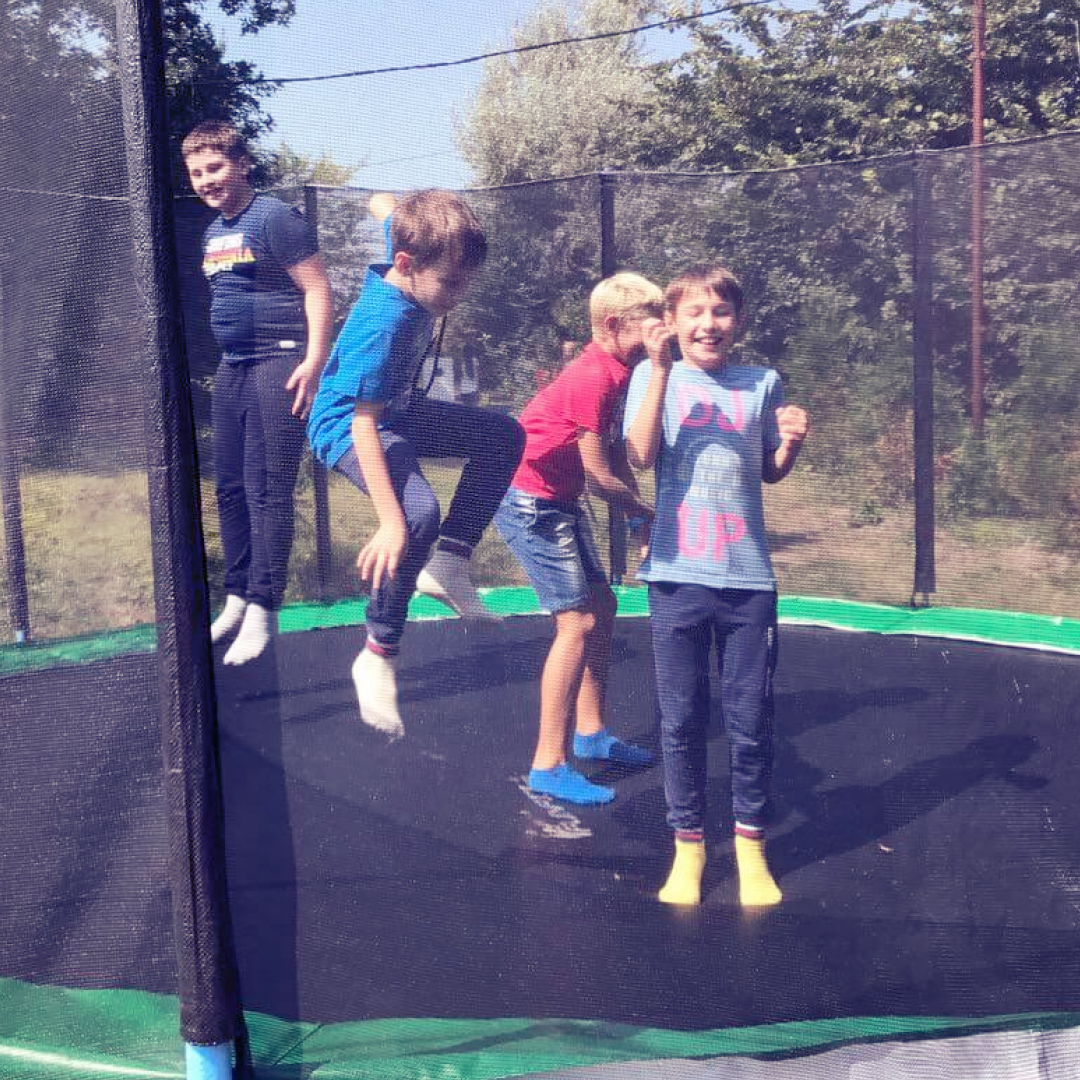 Школярі радісно стрибають на батуті в сонячний день