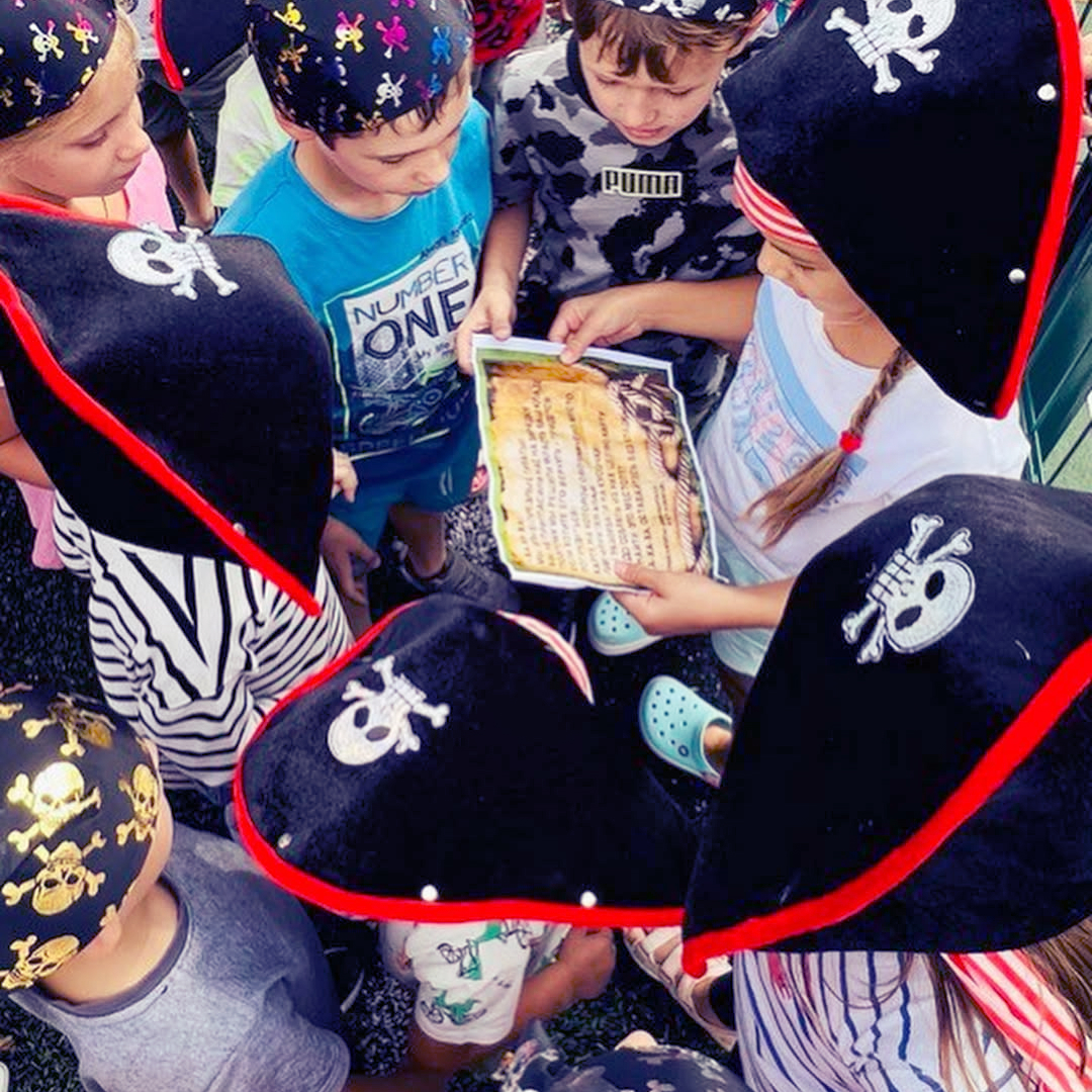 Діти під час шкільного літнього табору проходять квест піратської тематики в капелюхах