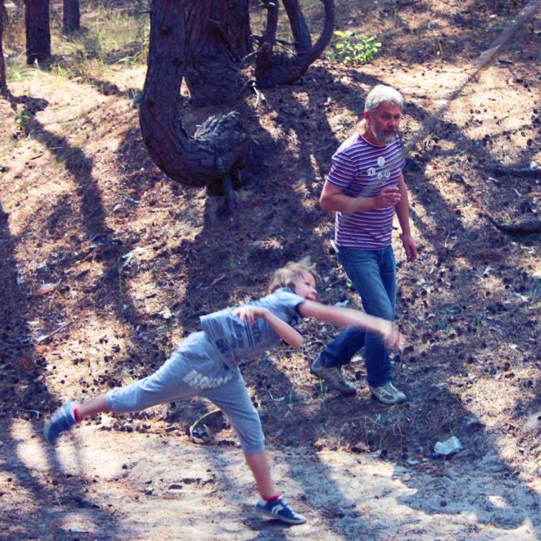 Хлопчик кидає списа в лісі під час літнього шкільного табору під керівництвом вчителя